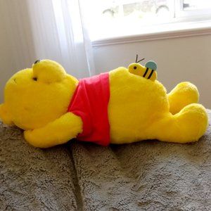 Cute Winnie the Pooh sunbathing with a bee on his stomach